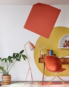 an orange chair sits in front of a yellow and red wall