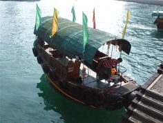 a small boat with flags on it in the water