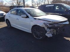 a white car that is sitting in the parking lot with it's hood up