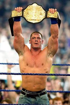 a man holding up a wrestling belt above his head