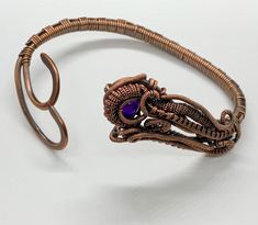 Hand woven copper coils and curves around a heavy gauge hammered copper frame with an amethyst bead accent. Approximately 6 3/4' adjustable to the wrist. Based on a Nicole Hanna Design. This bracelet has been antiqued, polished and sealed. Sealed with Protectaclear. ProtectaClear is a clear, protective coating that is tough enough to protect jewelry and is safe for wear against skin. ProtectaClear is practically invisible once applied and will seal and protect jewelry from tarnish, oxidation, an Hand Forged Adjustable Purple Jewelry, Adjustable Hand Forged Purple Jewelry, Adjustable Purple Copper Wire Jewelry, Adjustable Wire Wrapped Bronze Cuff Bracelet, Artisan Copper Cuff Bracelet Adjustable, Hanna Design, Spiritual Adjustable Copper Cuff Bracelet, Adjustable Electroformed Purple Jewelry, Adjustable Purple Electroformed Jewelry