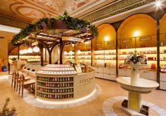 the inside of a store with lots of shelves and tables filled with drinks on display