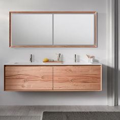 a bathroom vanity with two mirrors above it and a rug on the floor next to it