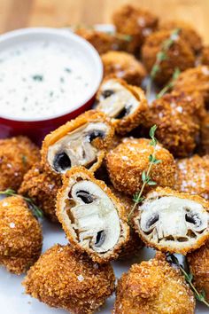 some fried food on a white plate with dipping sauce