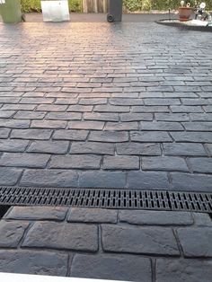 a fire hydrant sitting on the side of a road next to a brick walkway