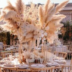 an elegant table setting with tall pamodia and white flowers in the centerpieces