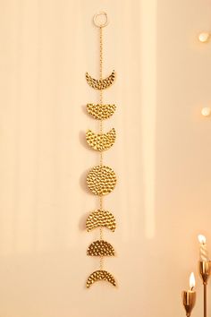 a gold chain hanging from the side of a wall next to a candle and some candles