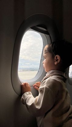 a young child looking out an airplane window