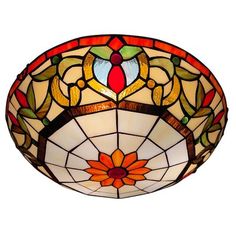 a stained glass ceiling light hanging from the ceiling in a room with dark walls and flooring