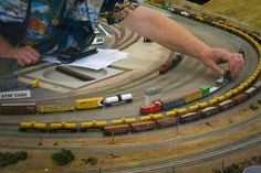 a man is playing with toy trains on the track