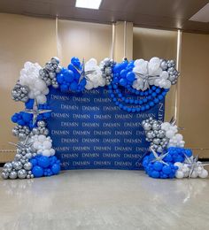 a blue and white balloon arch in an office lobby