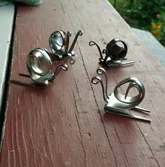 three pieces of metal art sitting on top of a wooden table next to each other