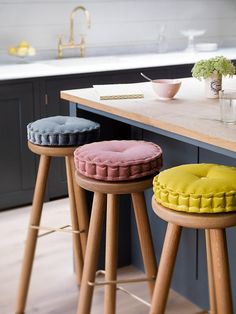 three stools in the middle of a kitchen