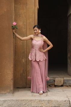 Featuring Onion Pink silk peplum with mirror, zardozi embroidered, paired with georgette inserted sharara and net choker dupatta with our signature hangings. Fabric - Silk, Georgette and net Components - 3 Colour - Onion Pink Embroidery details - Hand Embroidery Delivery time - 2-3 weeks Washing Instructions - Dry-clean Elegant Peplum Anarkali Set, Organza Palazzo Set With Dori Work For Navratri, Elegant Resham Embroidered Peplum Palazzo Set, Navratri Organza Palazzo Set With Dori Work, Elegant Peplum Palazzo Set With Resham Embroidery, Elegant Eid Peplum Set, Elegant Peplum Set For Eid, Festive Georgette Sharara With Dori Work, Floor-length Organza Palazzo Set With Cutdana