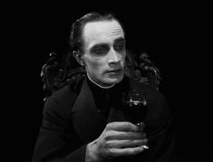 a man sitting in a chair holding a glass of wine