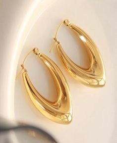 Chunky Oval V gold hoop earrings. These earrings can be your go to every-day earrings or a statement piece for a date night. They will add a chic and vintage look to your outfit! The earrings are made from stainless steel and 18k gold plating stainless stain. A perfect addition to your jewelry collection! • Materials: Stainless steel, -18k gold plating stainless steel. • Earrings Length: 33mm (1.6inches) • Earrings Width: 22mm (1.2 inches) .weight 9.5g a pair • This product is hypoallergenic and Trendy Oval Metal Hoop Earrings, Trendy Oval Hoop Earrings, Retro Small Hoop Gold Earrings, Trendy Oval Hoop Earrings As Gift, Trendy Oval Hoop Earrings For Gifts, Gold Oval Hoop Earrings For Party, Oval Hoop Earrings For Party, Chic Gold Oval Hoop Earrings, Trendy Oval Earrings For Party