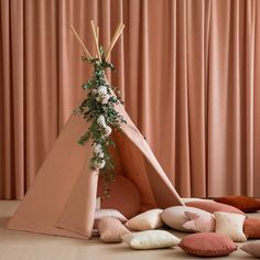 a teepee with flowers and pillows on the floor