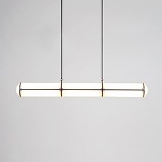 three lights hanging from the ceiling in a room with white walls and flooring,