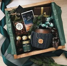 a gift box filled with chocolates, nuts and other holiday treats sits on a table