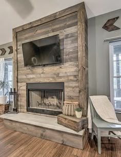 a living room with wood floors and a large tv mounted on the wall above the fireplace