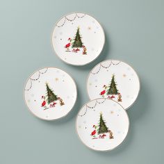 three plates with christmas designs on them sitting next to each other in front of a gray background