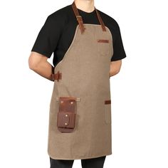 a man wearing an apron and holding a brown leather tool holder in his right hand