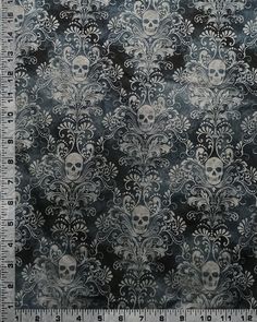 a black and white fabric with skulls on it, in the middle of a ruler