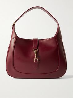 Gucci's small 'Jackie' bag takes its curved silhouette from the original style that debuted in the '60s and even boasts the same gold-tone piston clasp. Crafted in Italy from burgundy leather, it's suspended on a thick strap that can be adjusted to your perfect drop. It has plenty of space inside for everyday essentials, like your wallet, keys, cell and compact. Gucci Bags With Metal Hardware For Work, Classic Gucci Bags With Gold-tone Hardware, Gucci Leather Bags With Brass Hardware, Classic Gucci Shoulder Bag With Gold-tone Hardware, Gucci Shoulder Bag With Brass Hardware For Evening, Gucci Leather Shoulder Bag With Brass Hardware, Gucci Bags With Gold-tone Hardware For Work, Gucci Shoulder Bag With Brass Hardware For Formal Occasions, Gucci Formal Shoulder Bag With Brass Hardware