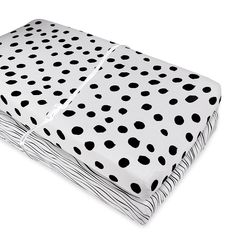 a white and black polka dot sheet set on top of each other, folded up