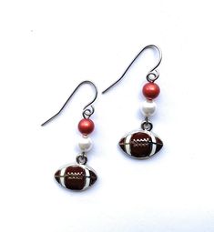 a pair of earrings with a football on it