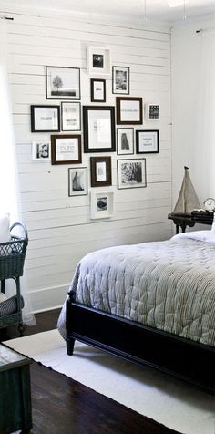 a bed sitting in a bedroom next to a window with pictures on the wall above it