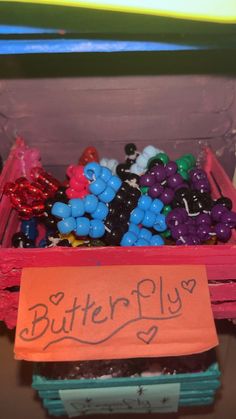 a box filled with lots of different colored candies next to a sign that says butterfly