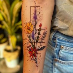 a woman's arm with flowers on it and a cross in the middle,