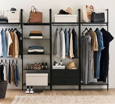 an organized closet with clothes, shoes and handbags hanging on the wall next to it