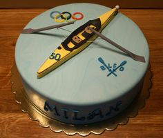 a cake decorated with a kayak and olympic symbols