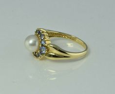 "14K Yellow Gold Pearl and Tanzanite ring, 6.5mm white pearl center, tanzanite halo, 12 stones, .5\" across ring, Ring size 7, Circa 1990, 3.9 grams Stock # BB234R23 Most rings are sizable for a small fee. If the ring you are considering is the incorrect size contact us for a quote. This listing contains photographs of the actual item you will receive. Our items are in excellent condition with little or no signs of wear and many are one of a kind pre-owned estate finds. Please look closely at th Classic Multi-stone Pearl Ring For Formal Occasions, Formal Multi-stone Pearl Ring In Fine Jewelry Style, Gold Coin Ring, 12 Stones, Tanzanite Ring, Coin Ring, New Bands, White Band, Fine Jewelry Designers