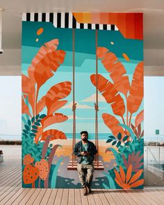 a man sitting on a bench in front of a painting that looks like tropical plants