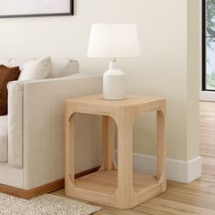 a living room with a couch, table and lamp on the floor in front of it