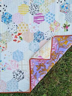 two quilts laying on the grass next to each other