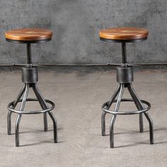 two metal stools with wooden seat on concrete floor