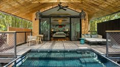 the inside of a house with a pool and patio furniture on it's deck