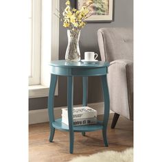 a blue table with some flowers in a vase on top of it next to a chair