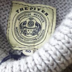 a close up of a knitted sweater with a label on it