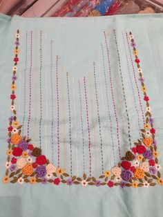 a piece of cloth with flowers and beads hanging from it's sides on a table