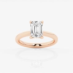 an emerald - cut diamond engagement ring on a white background