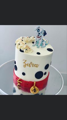 a white and black polka dot cake with red ribbon