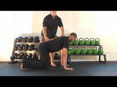 two men in black shirts are doing exercises with green kettles