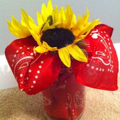 a sunflower in a mason jar with red bandannas and polka dot bow