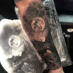 a man's arm with a full moon and trees on it