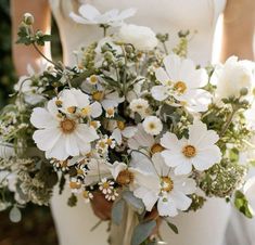 a bride holding a bouquet of white flowers